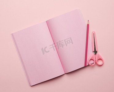 在粉红色背景上打开带有空白粉红色页面的笔记本