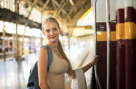 年轻女子在老式火车上等车，在泰国曼谷的车站月台上放松而无忧无虑，然后才赶上火车。