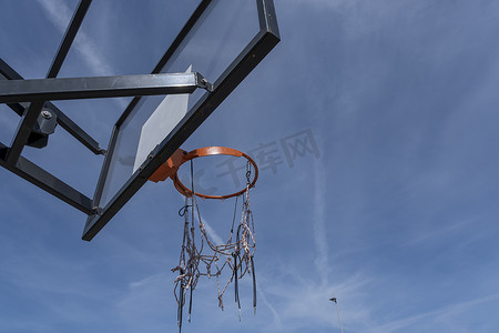 在万里无云的温暖夏日天空下，带红色圆环的篮球架