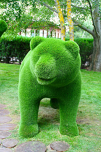 手工雕塑摄影照片_公园里用人造草制成的熊雕塑。