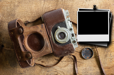 带皮套和宝丽来框架的老式胶片相机，用于在旧木背景上进行模拟