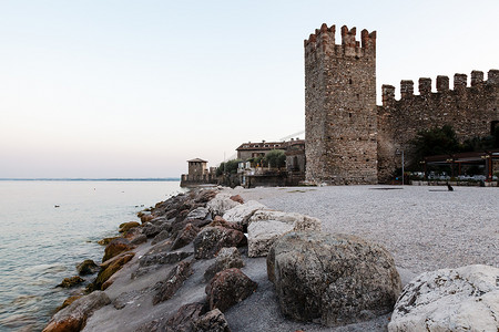 “西尔苗内加尔达湖岩石海滩上的中世纪城堡”