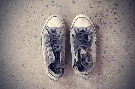 水泥地板上的旧运动鞋。