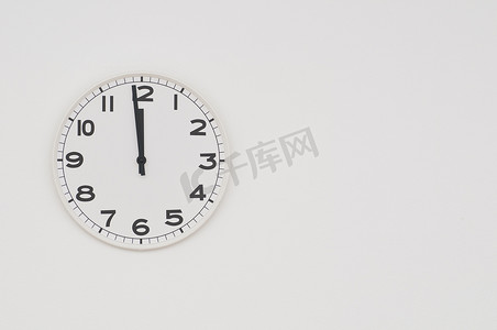 “黑色指针的白色时钟显示还有一分钟到午夜，正午”