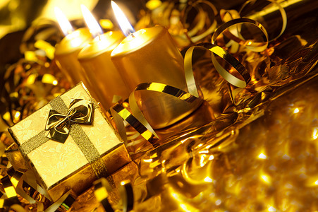 礼盒蝴蝶结摄影照片_金色圣诞蜡烛和金色礼盒