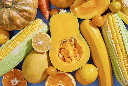 秋天的背景摄影照片_蓝色背景中新鲜黄色水果和蔬菜的收集