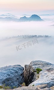 秋天的露水摄影照片_山顶岩石，昏昏欲睡的迷雾景观在晨雾中咆哮。