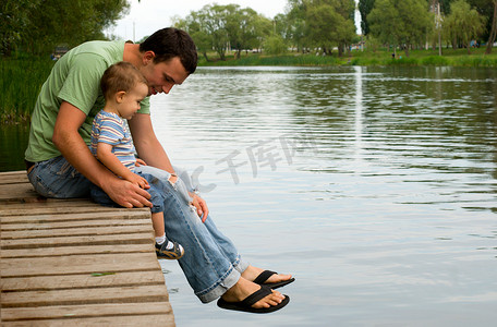 父亲节拥抱摄影照片_父亲和儿子在河边