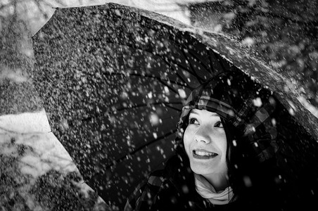 暴风雪中带伞的年轻女子