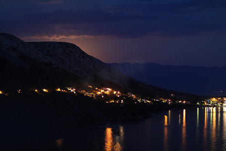 月光下的夜景，从克罗地亚的岩石山到亚得里亚海沿岸的城市，不同的色调