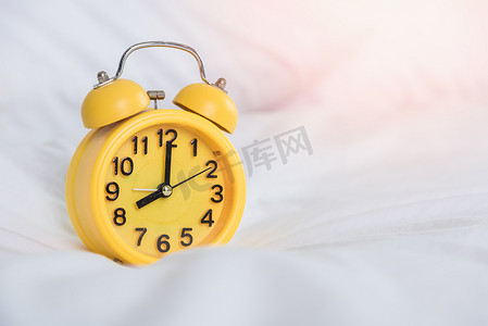 早上 8 点在床上的黄色闹钟