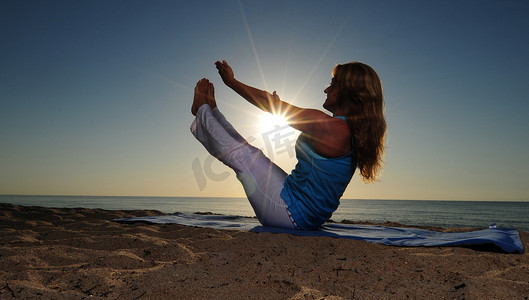 瑜伽摄影照片_海滩上的全船瑜伽姿势