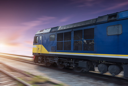 货运铁路摄影照片_日落时的快速货运蓝色火车
