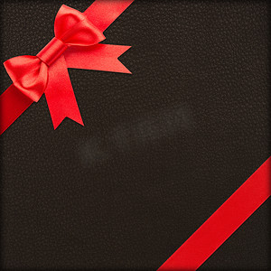 蝴蝶结黑色红色摄影照片_带红色蝴蝶结的棕色礼物