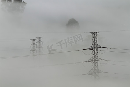 网格出现摄影照片_出现从薄雾的电力线和定向塔