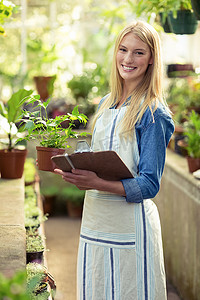 检查盆栽植物的年轻女园丁