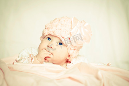 粉红色帽子摄影照片_戴着粉红色帽子的女婴