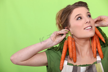 滑稽表演摄影照片_一位戴着胡萝卜作为耳环的女厨师