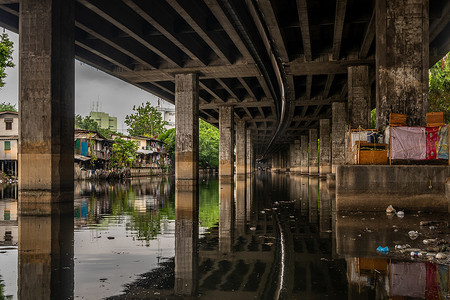 在曼谷 Khlong Toei 高速公路下的 Khlong Phra Khanong 河上，可以看到美丽的过滤光的透视图。