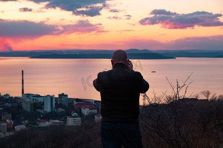一名男子在日落时拍摄符拉迪沃斯托克市的全景。