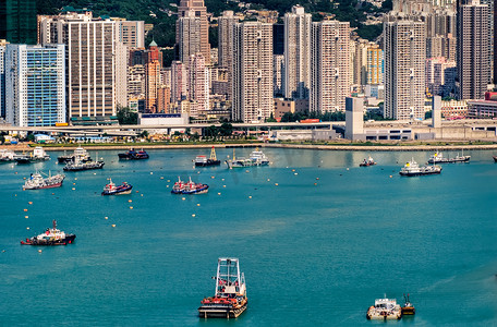 划船小船摄影照片_摩天大楼附近港口的五颜六色的小船