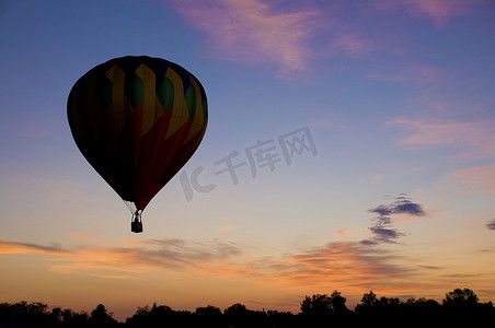 漂浮的热气球摄影照片_漂浮在微红黎明天空的热气球