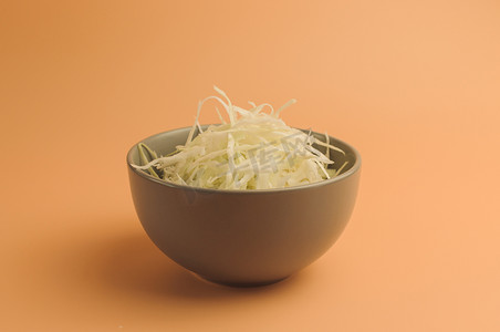 米色背景上切碎的白菜、碗里的白菜、极简主义风格的切碎白菜、乡村蔬菜、素食产品、维生素、健康饮食理念。