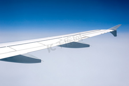 在高空多云的天空从机载飞机窗口查看。