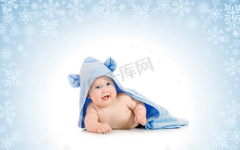 有在多雪的背景的小微笑的婴孩