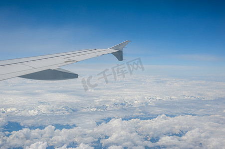 在高空多云的天空从机载飞机窗口查看。