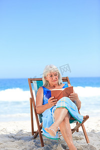 在沙滩上看书的高级女人