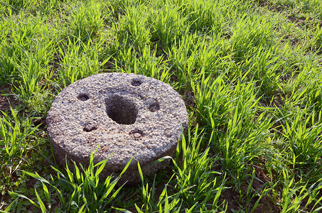 春天石材摄影照片_在冬天庄稼春天领域的老磨石