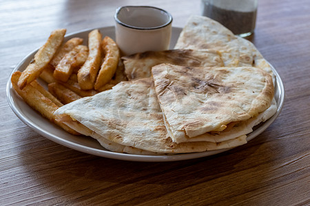 饼类摄影照片_盘子里的炸薯条和油炸玉米粉饼