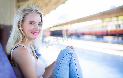 年轻女子在老式火车上等车，在泰国曼谷的车站月台上放松而无忧无虑，然后才赶上火车。