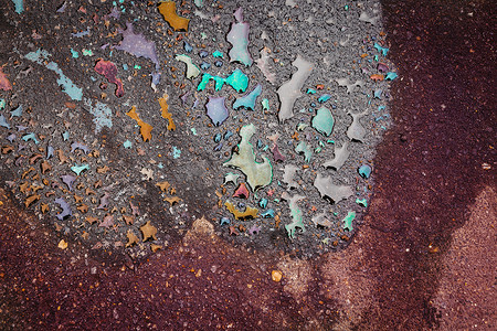 油渍摄影照片_雨后沥青路面上的油渍。