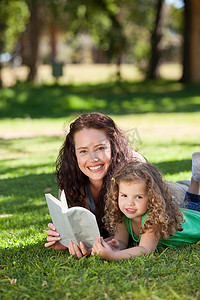 读书的女人摄影照片_带着女儿读书的女人