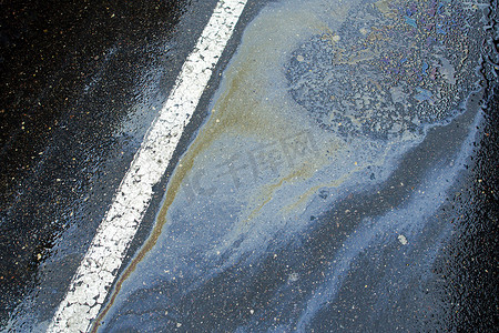 彩色油渍关闭，人行道上汽油污渍的颜色作为纹理或背景。