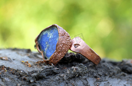 半镶嵌摄影照片_手工制作的铜戒指，镶嵌蓝色半宝石