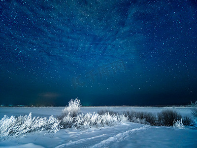 在田野和繁星点点的无月冬日天空下雪