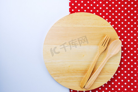 “桌子背景上的木盘、桌布、勺子、叉子”