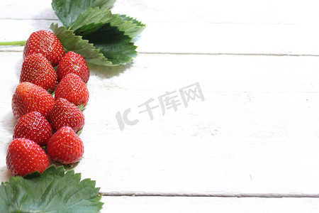 水果边框摄影照片_白色木板上的草莓边框