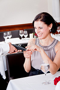 餐馆吃饭摄影照片_在餐馆吃饭的男人和女人用信用卡支付