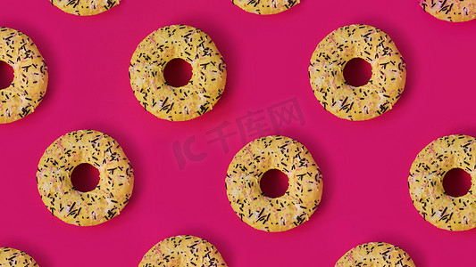 粉红色背景中一排排甜甜圈的节日创意图案