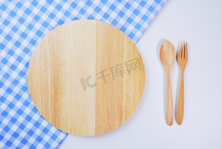 “桌子背景上的木盘、桌布、勺子、叉子”