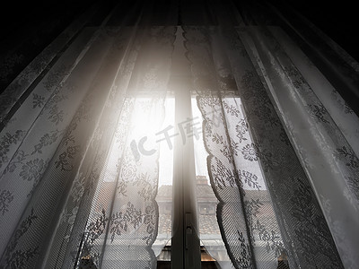 阳光透过带蕾丝窗帘的窗户