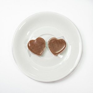 咖啡杯盘上的爱心形状巧克力