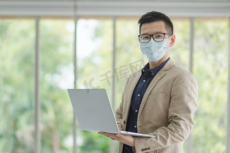 企业员工在办公室工作期间戴口罩以保持卫生遵守公司政策。