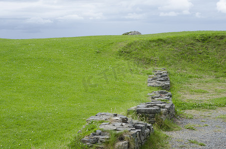 城堡墙切割明亮的绿色草地