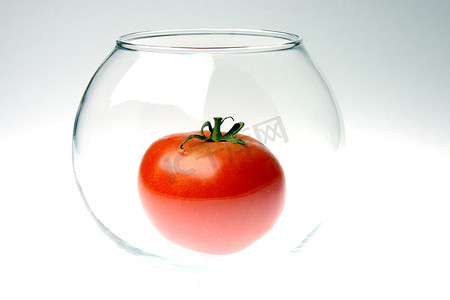 渐变背景中玻璃圆罐中的红熟番茄