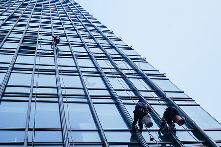 城市建筑玻璃摄影照片_清洁工正在清洁建筑玻璃